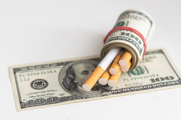 cigarettes and money. expensive habit. white background - horizontal photo.