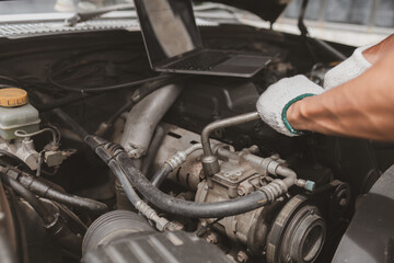Car mechanic is inspecting the engine of a car coming in for repair at the center. Professional engine specialist, car repair, car breakdown. Car maintenance and repair concept.