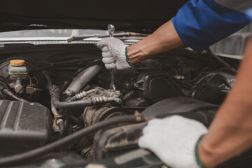Fototapeta premium Car mechanic is inspecting the engine of a car coming in for repair at the center. Professional engine specialist, car repair, car breakdown. Car maintenance and repair concept.