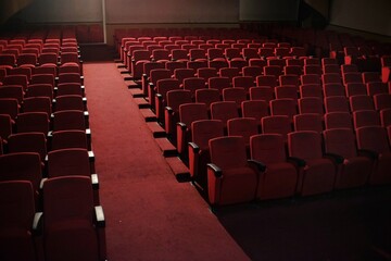 Rows of red chairs in an entertainment performance hall.