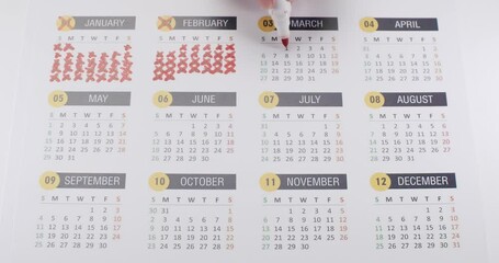 Person hand crossed out every day at year in paper calendar. Marking dates with red marker when task is done. The end of 2023 year. Passing time concept. annual calendar. Plan Organize.