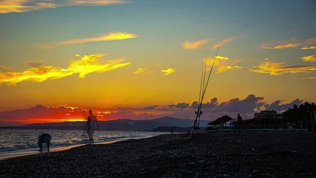 fishermen on the beach of Playa de Torrox in Spain during sunset.