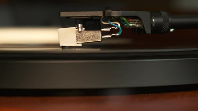 Close up view of a turntable needle with platter spinning, slow motion 4K