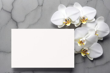 White blank card and orchid flowers on grey background. Flat lay, top view