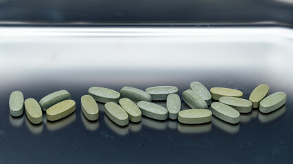 pills and vitamins on a stainless steel tray