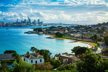 Looking over historical suburb of Devonport on the shore of Auckland Harbour. Distant skyline of Auckland CBD on the horizon. North Island, New Zealand - obrazy, fototapety, plakaty