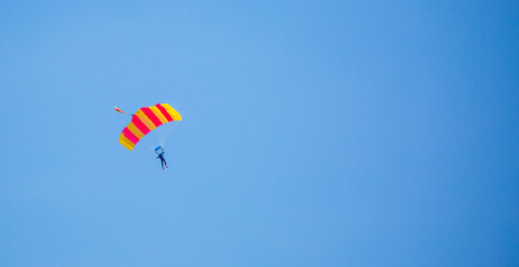 Skydiving. Flying parachutists against the background of the blue sky and mountains. Extreme sport and entertainment.