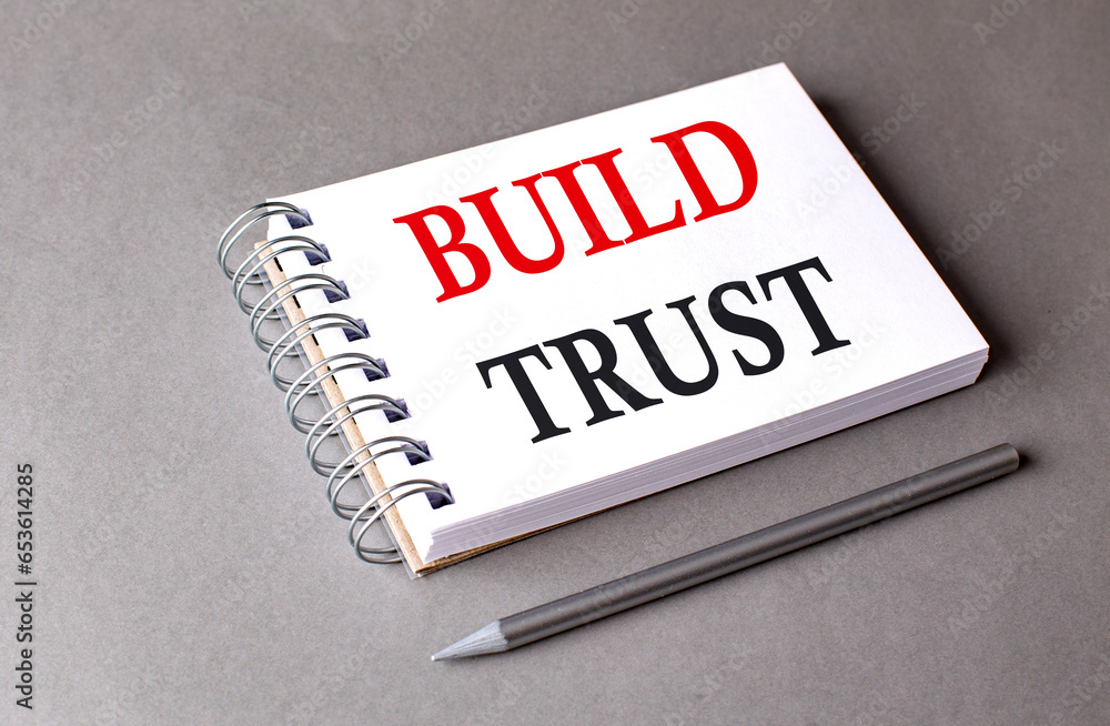 Poster build trust word on notebook on grey background