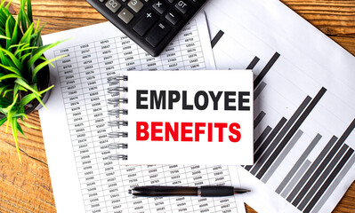 EMPLOYEE BENEFITS text on a notebook with chart and calculator