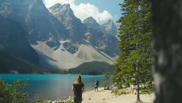 A woman are hiking at the shaw of Moraine Lake in Banff National Park of Canada, on a clear blue day 