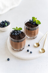 Homemade delicious chocolate mousse or panna cotta in glasses decorated with chocolate cookie...
