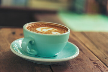 Latte art coffee cup with milk on wooden table. Espresso shot make latte art hot coffee cup. Cappuccino with milk in italian coffee shop cafe. Brown hot caffeine beverage in cafeteria with copy space
