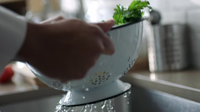 Person rinsing some vegetables in a strainer