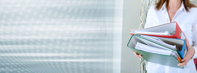 Businesswoman holding binders; panoramic banner