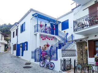 Beautifully decorated house in white and blue colors and decorative elements like bicycle in rustic village of Panagia , Thassos Island , Greece