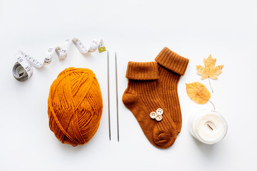 Set for knitting children's socks. Orange threads, knitting needles, buttons, centimeter.