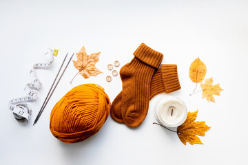 Set for knitting children's socks. Orange threads, knitting needles, buttons, centimeter.
