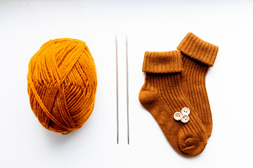 Set for knitting children's socks. Orange threads, knitting needles, buttons, centimeter.