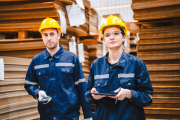 Professional worker in safety uniform hard hat, supervisor inspector packaging stock order at factory warehouse, piles of stacking paper manufacture, recycling production industry.