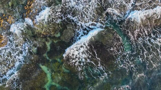 Sea waves with sea foam splash crashing on rocky shoreline