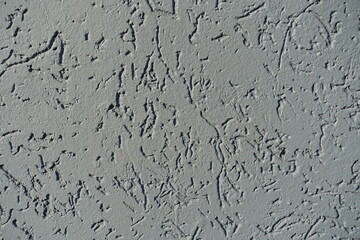 Close shot of gray wall with stucco worm swirl finish