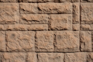 Close shot of brown concrete brick veneer wall with random layout