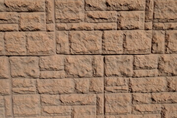 Surface of brown concrete brick veneer wall with random layout