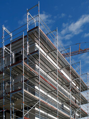 building under construction with scaffolding in place over blue sky
