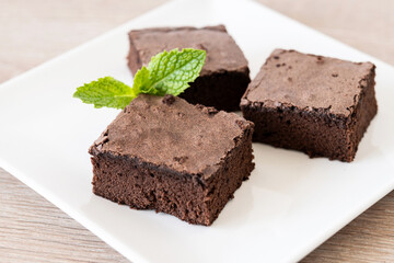Chocolate brownie portion on wooden table. Close up