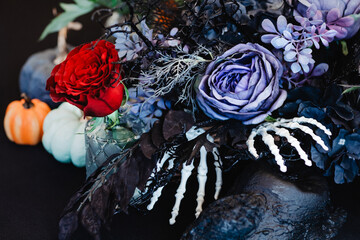 Autumn composition in dark tones with a purple rose in the centre. The theme of the holiday Halloween.