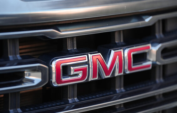 New York, USA - 3 September 2023: The logo sign of GMC, General Motors Corporation, an iconic American car manufacturer, in front of a SUV.