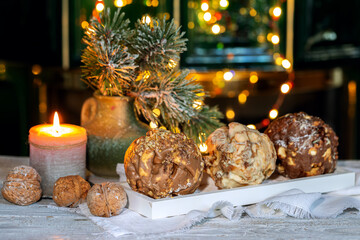 Christmas German dessert Schneeballen in front of a fireplace with lights on a dark background
