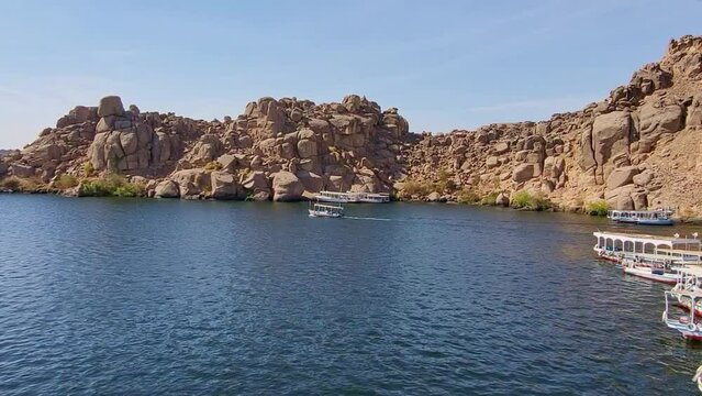 Port with barges on the Nile River next to the Temple of Philae. Navigation on the Nile. Egypt.