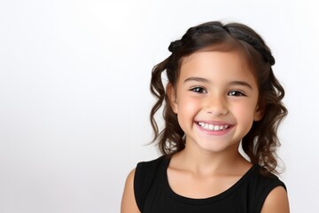 Adorable six years old girl in black top isolated on white studio background, pretty brown-haired fringe hairstyle european appearance child pose indoor smiling look at camera.