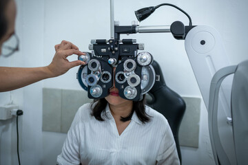 Woman optical shop customer doing eyesight measurement with optical phoropter check eye distance for eyeglasses is optical eye shop service.	
