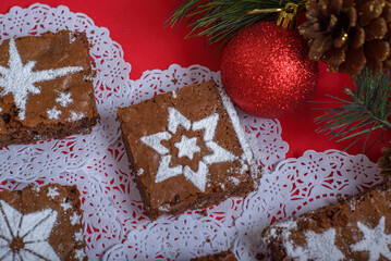 Chocolate brownies with icing sugar decorations together with Christmas decorations. Christmas...