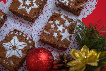 Chocolate brownies with icing sugar decorations together with Christmas decorations. Christmas...