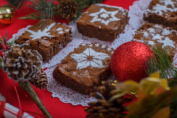 Fototapeta na wymiar Chocolate brownies with icing sugar decorations together with Christmas decorations. Christmas background and dessert.