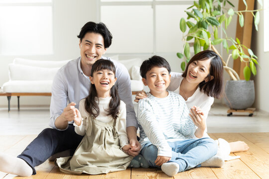 床に座り微笑む4人家族