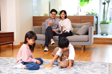 ソファ周りで団欒している4人家族