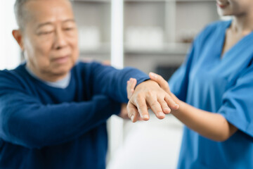 Obraz premium senior man doing exercise at clinic with physiotherapist. help of a personal trainer during a rehabilitation session.