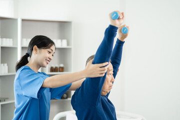 senior man doing exercise at clinic with physiotherapist. help of a personal trainer during a rehabilitation session.