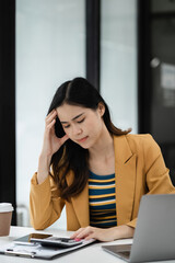 Stress businesswoman is sitting at table, under stress from working.