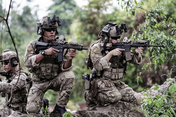 Military army soldiers tactical team, commando group moving cautiously in forest area, kneeling and...
