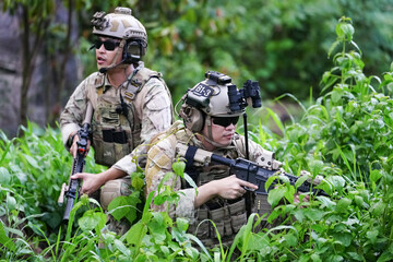 Military army soldiers tactical team, commando group moving cautiously in forest area, kneeling and...