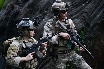 Military army soldiers tactical team, commando group moving cautiously in forest area, kneeling and...