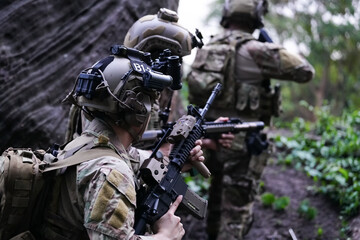 Military army soldiers tactical team, commando group moving cautiously in forest area, kneeling and looking around, covering comrades, controlling sectors. Commander showing halt or stop hand signal