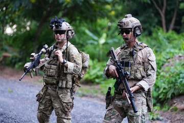Military army soldiers tactical team, commando group moving cautiously in forest area, kneeling and...