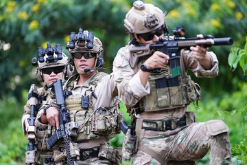 Military army soldiers tactical team, commando group moving cautiously in forest area, kneeling and...