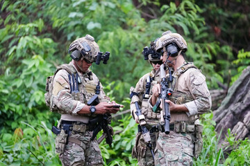 Military army soldiers tactical team, commando group moving cautiously in forest area, kneeling and...